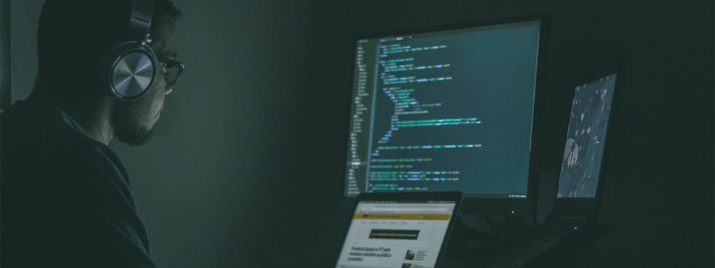 A developer coding on two desktops.